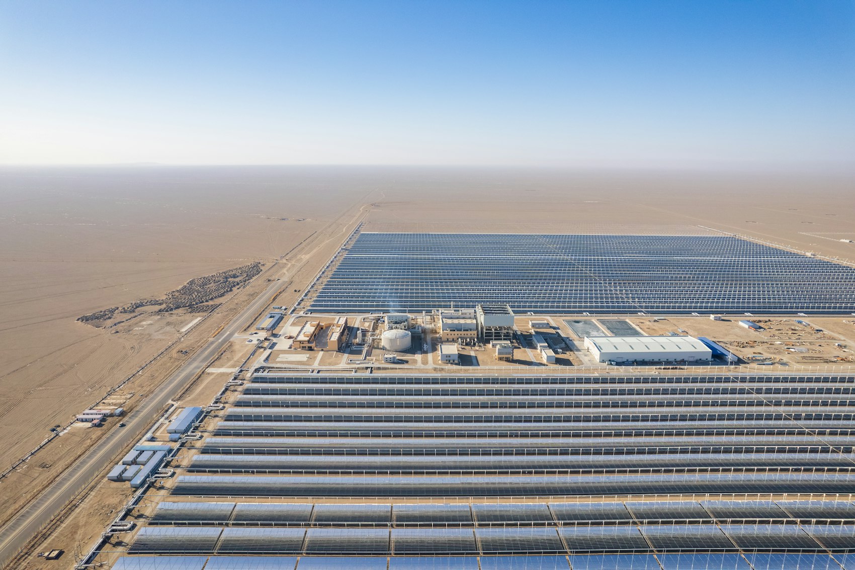 Vista aérea de una gran planta solar industrial con cientos de paneles
